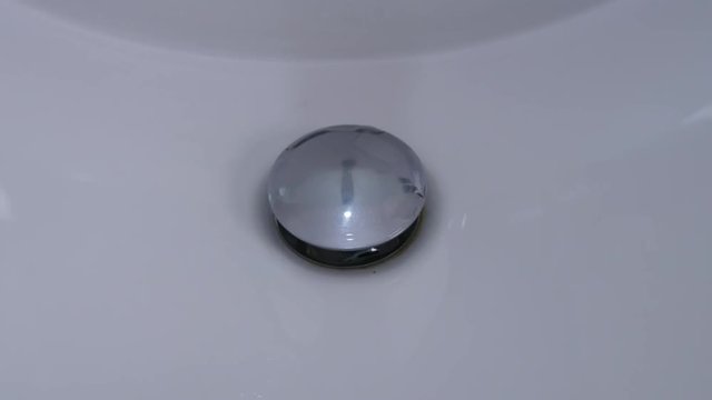 Water Image Draining from a Sink in Home Bathroom