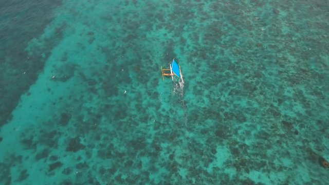 aerial footage sailboat with blue sails. Sailing yacht on sea surface