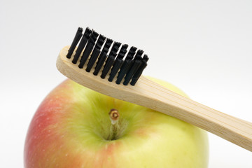 holzzahnbürste mit schwazen borsten auf apfel