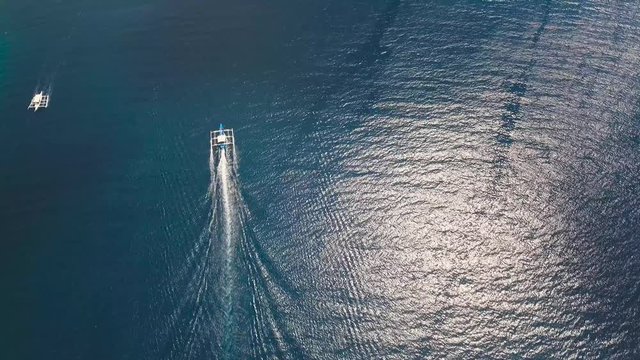 aerial footage motorboat in blue sea. motorboat floating in a turquoise blue sea water. Sea landscape with wake of small fast motorboat. Tropical landscape.