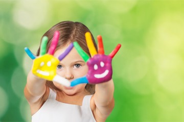 Cute little girl with colorful painted hands on  background
