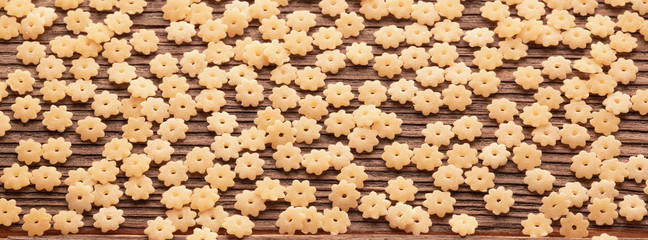 Dry uncooked pasta texture background on wooden table
