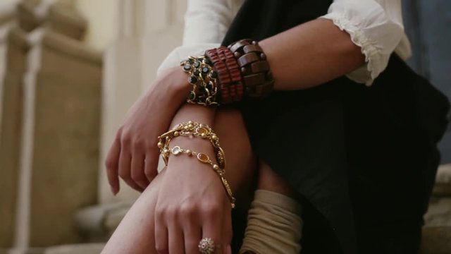 Close up view of gentle female hands with boho style bracelets and rings. Fashion concept, jewelry, magazine cover. Photo session, photo shoot.