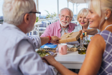 Thank you. Nice aged people looking at their friend while taking the present