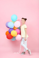 Cute young girl with colored balloons on pink background