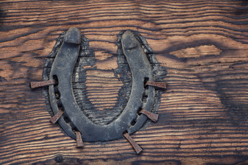 Old horseshoe nailed to a wooden board. Close up