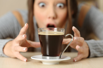 Amazed woman looking at coffee cup