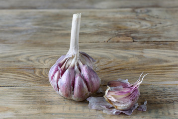 Garlic and a few cloves of garlic on a wooden kitchen table.