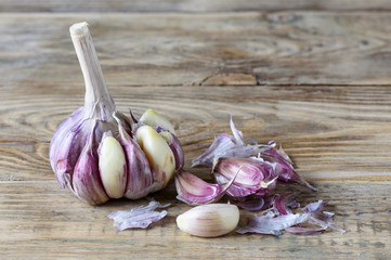 Slightly peeled garlic on a wooden kitchen table