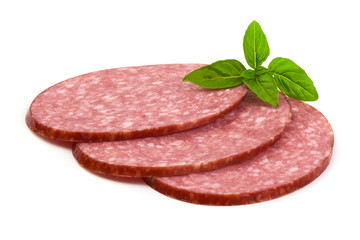 Dry salami sausage slices with basil leaves, isolated on white background.