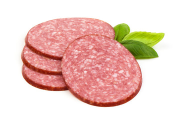 Dry salami sausage slices with basil leaves, isolated on white background.
