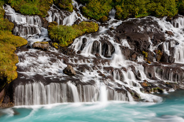 Hraunfossar Barnafoss waterfall Iceland, a series of waterfalls formed by rivulets streaming over a...