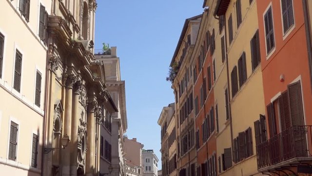 Beautiful european urban architecture. Cozy colorful italian street. Exterior of old residential buildings in center of Rome, Italy. Camera moving up in slow motion