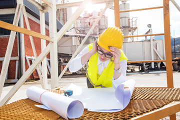 Confident female architect working with blueprints