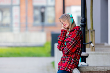 Young blond girl with headphones at urban outdoor