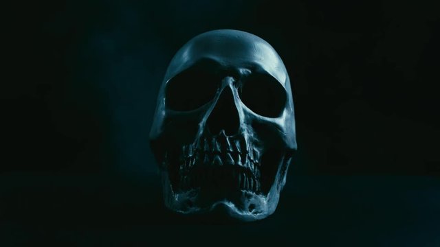 Skull in darkness with smoke, stabilizer camera movement