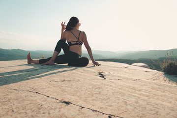 Fototapeta na wymiar woman doing yoga on the top of a mountain during sunset