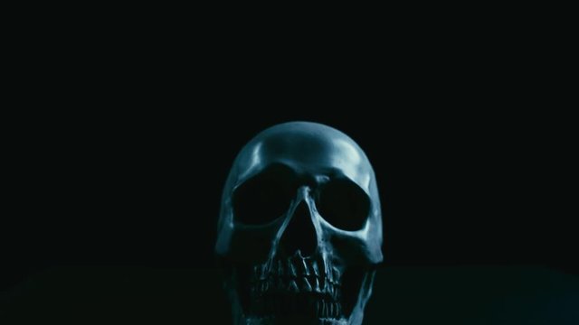 Skull in darkness,vertical stabilizer camera sudden movement and smoke appearance