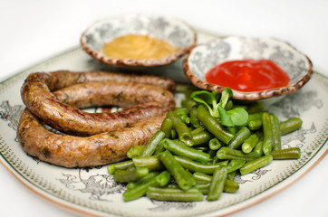 Hunting sausage with green beans with mustard and ketchup on a plate. Homemade sausage in a restaurant. German dish to beer.