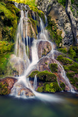 Fototapeta premium Beautiful natural waterfall over rocks and moss