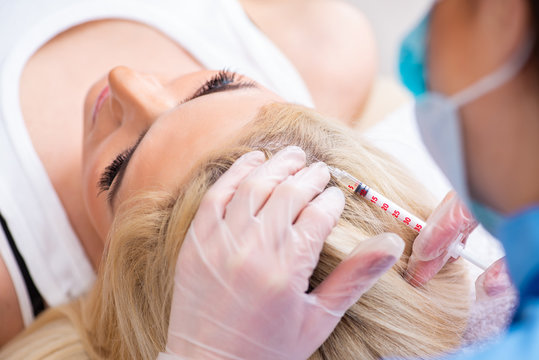 Plastic surgeon preparing for operation on woman hair 