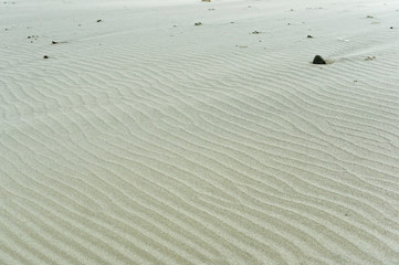 Wavy sand surface. Sandy smooth sea shore. Sand ripples.