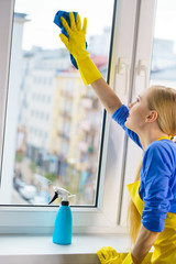 Woman cleaning window at home