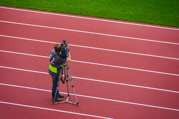 Video operator shoots on the camera sports competitions at the stadium
