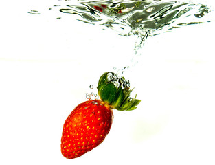 Strawberry dropped into liquid for artistic shot