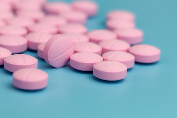 Obraz na płótnie Canvas pink pills on blue background