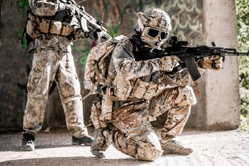 Fototapeta premium Special forces soldiers in action. Elite squad sneaks up on the enemy in a dilapidated building on the outskirts of the city