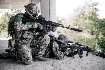 Military soldiers in camouflage took a firing position in the destroyed, abandoned building of the...