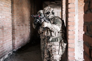 Soldiers in camouflage stormed the building aiming at the enemy