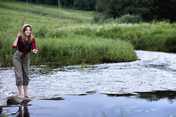 Fototapeta na wymiar Girl by the river with a fishing rod