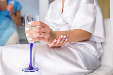the girl in the negligee holds a glass of champagne in her hands