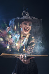 Young witch with a wand and a spellbook casting a spell in her ritual, halloween concept