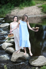 Beautiful girls in dresses on the river