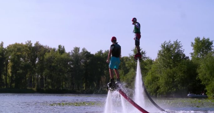 Two Flyboarders flying doing tricks slow motion Flyboarding medium shot video