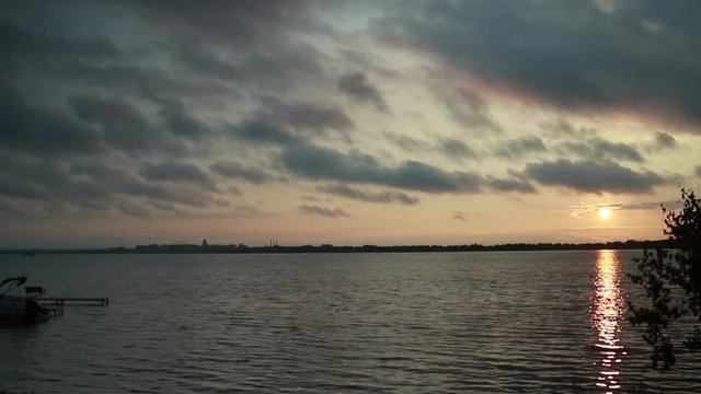 Midwestern summer sunset over the beautiful city of Madison, Wisconsin and Lake Monona.  The sun casts beautiful colors and reflections into the sky, clouds, and water.