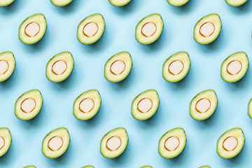Creative layout made of fresh avocado. Flat lay. Food concept. Avocado on blue background.