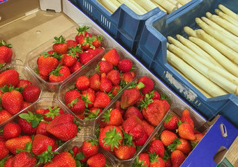 Trays with fresh strawberries and white asparagus