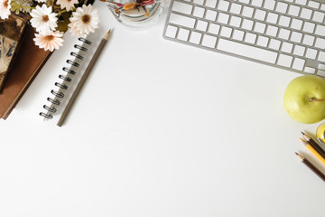 Topview office desk keyboard computer and book, colour pencil with notebook paper on white table with workspace.