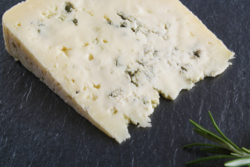 blue cheeseon a stone background, rosemary