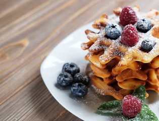 Blueberry waffles with raspberries and sugar powder for breakfast,