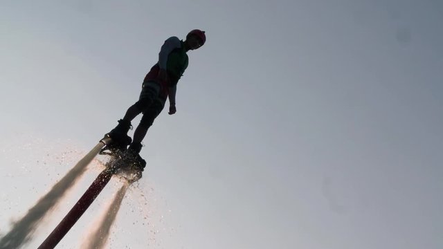 Flyboarder flying Flyboarding medium shot video on sunset backlight