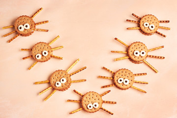 Group of double Halloween spider cookies on pink wooden background