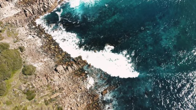 Aerial view of Whale carcus washed up on Injidup beach in Margaret river, Western Australia, next to blue water, waves and smooth beach rocks, on a sunny day