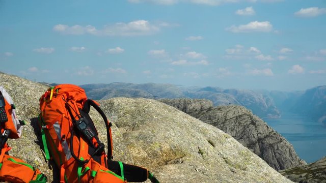 Emergency crew backpacks in the mountains at preikestolen in Norway laying on the ground waiting for call from satellite phone.