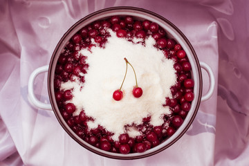 cherries covered with sugar in a bowl for cooking jam