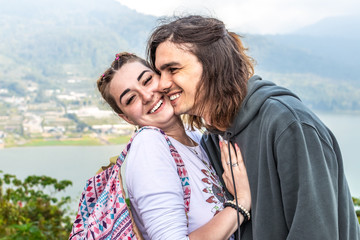 Portrait of beautiful young couple enjoying nature on a mountain background.